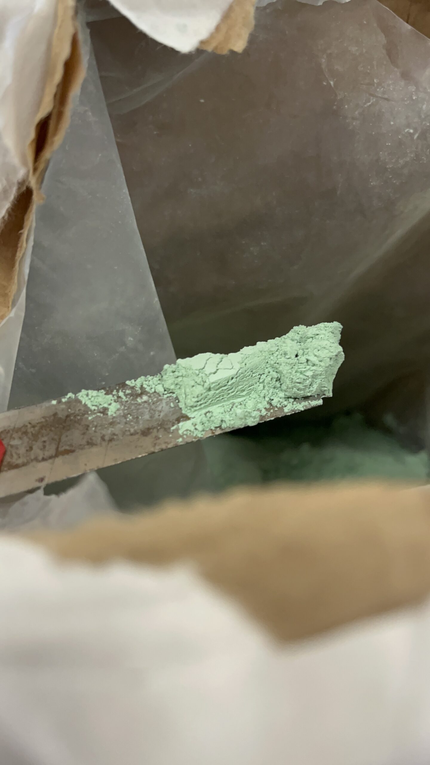 Zielony proszek Sulfa-Copper na łopatce podczas pobierania z worka