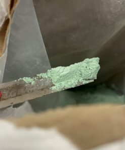 Zielony proszek Sulfa-Copper na łopatce podczas pobierania z worka